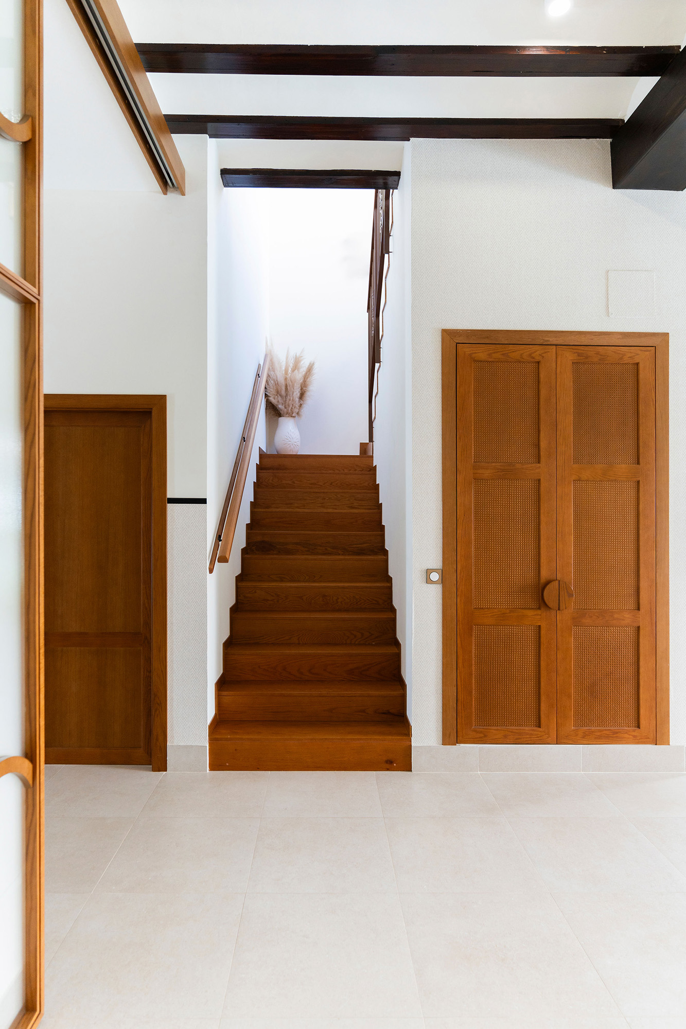 Rehabilitación interior de Casa Sofia: salón comedor abierto a la cocina, con vigas de madera vistas y luz natural.