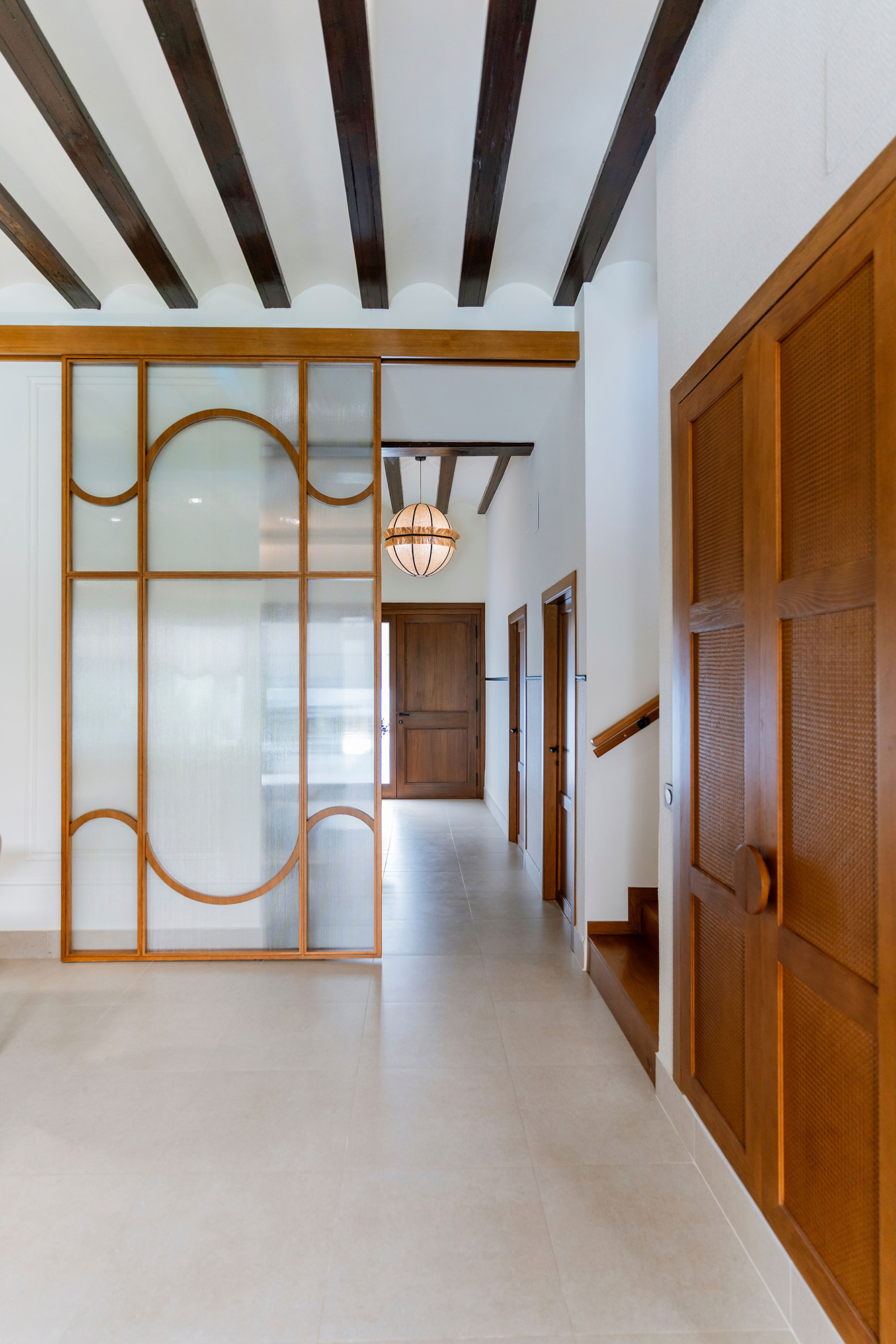 Rehabilitación interior de Casa Sofia: salón comedor abierto a la cocina, con vigas de madera vistas y luz natural.