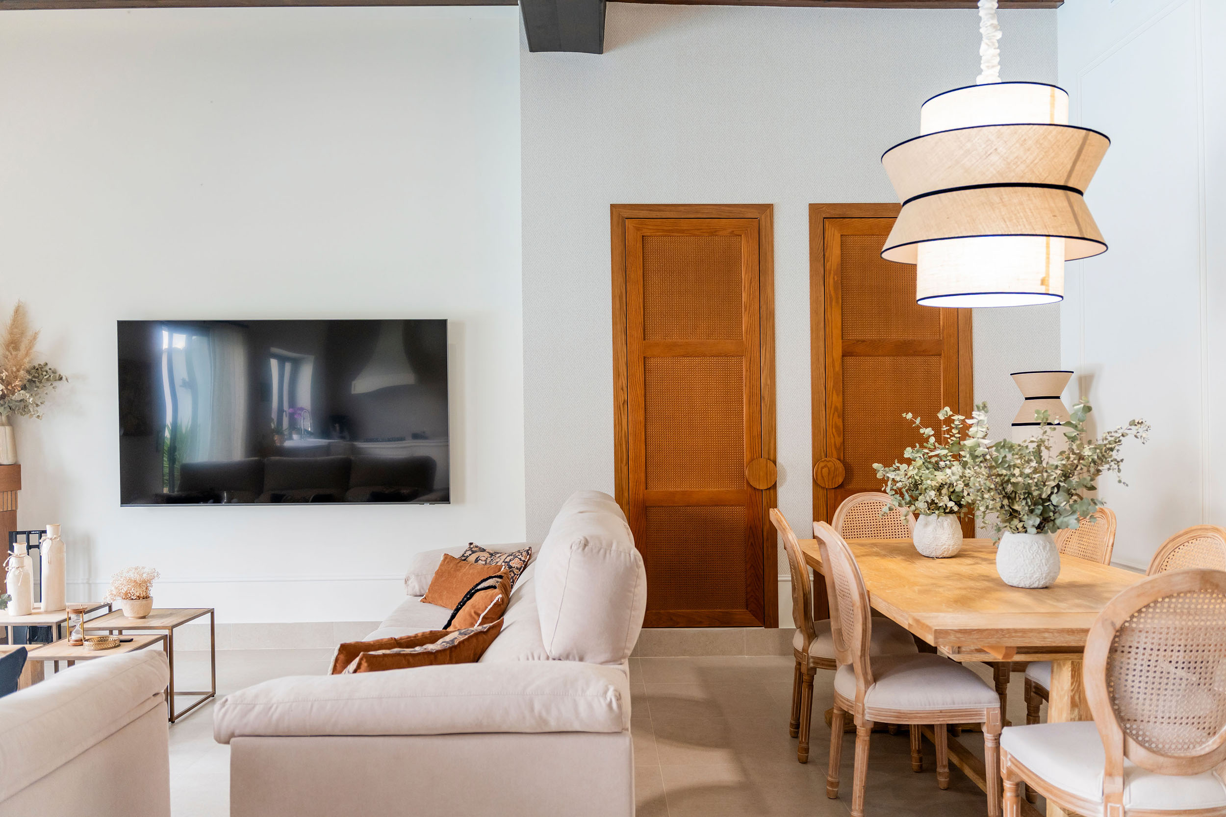 Rehabilitación interior de Casa Sofia: salón comedor abierto a la cocina, con vigas de madera vistas y luz natural.