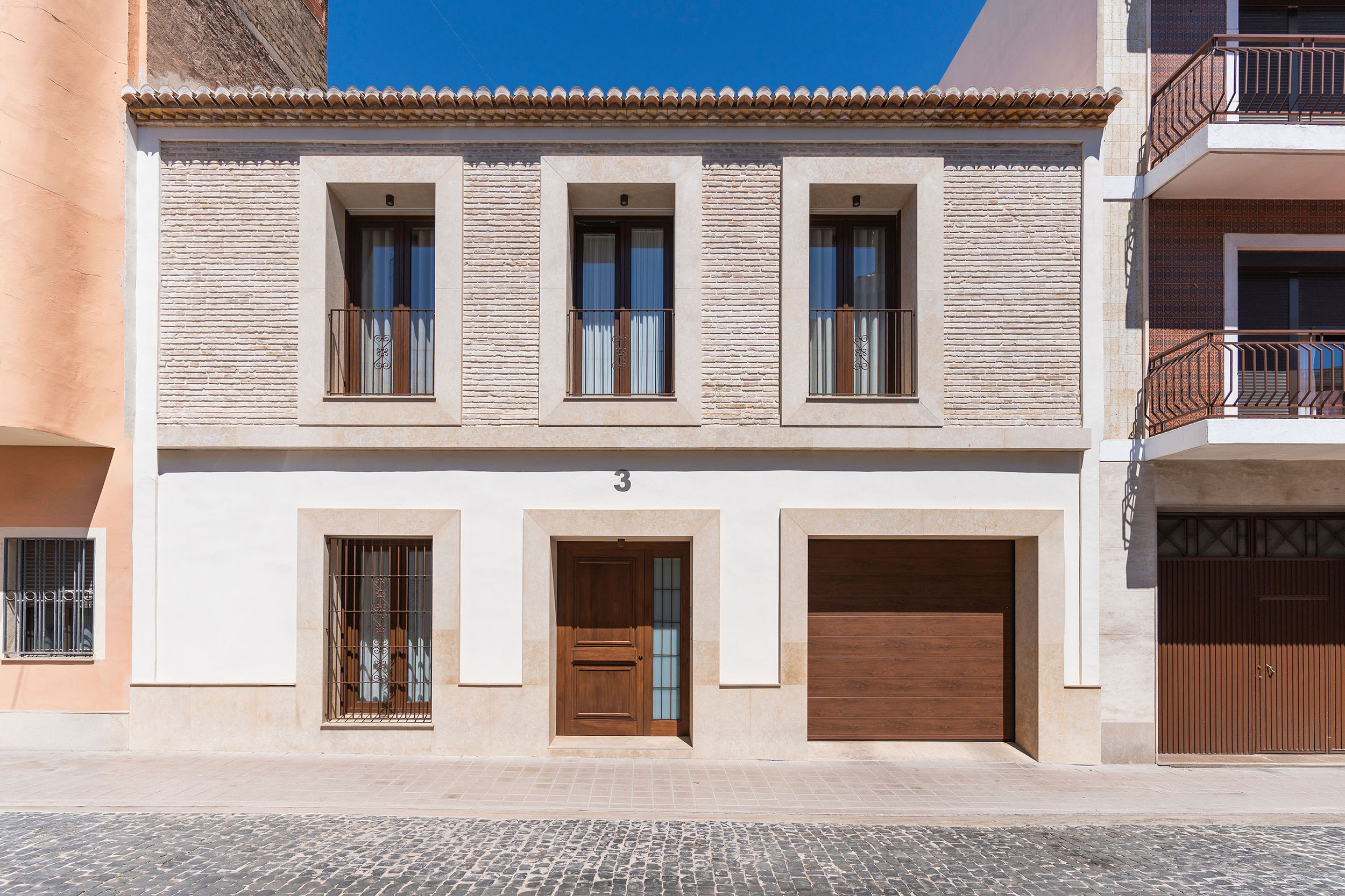 Fachada rehabilitada de Casa Sofia con ladrillo caravista recuperado y acabados de piedra natural.
