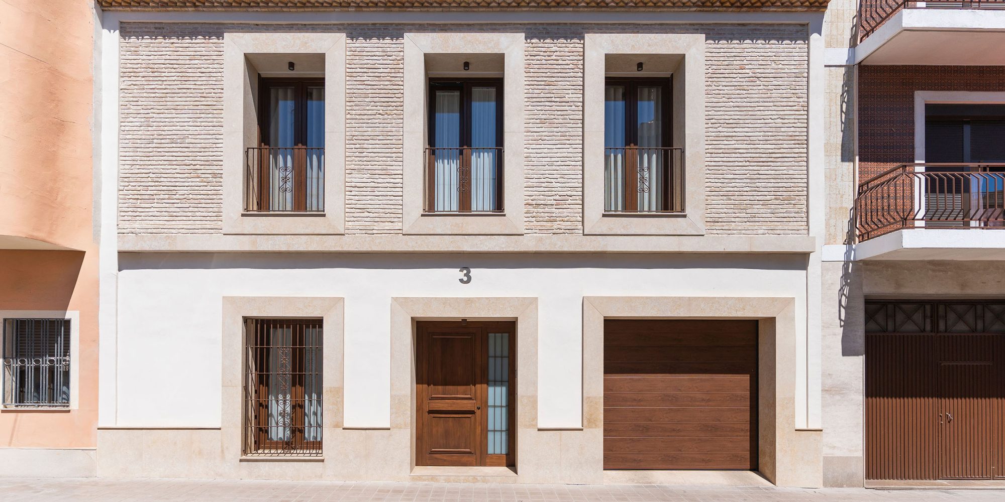 Fachada rehabilitada de Casa Sofia con ladrillo caravista recuperado y acabados de piedra natural.